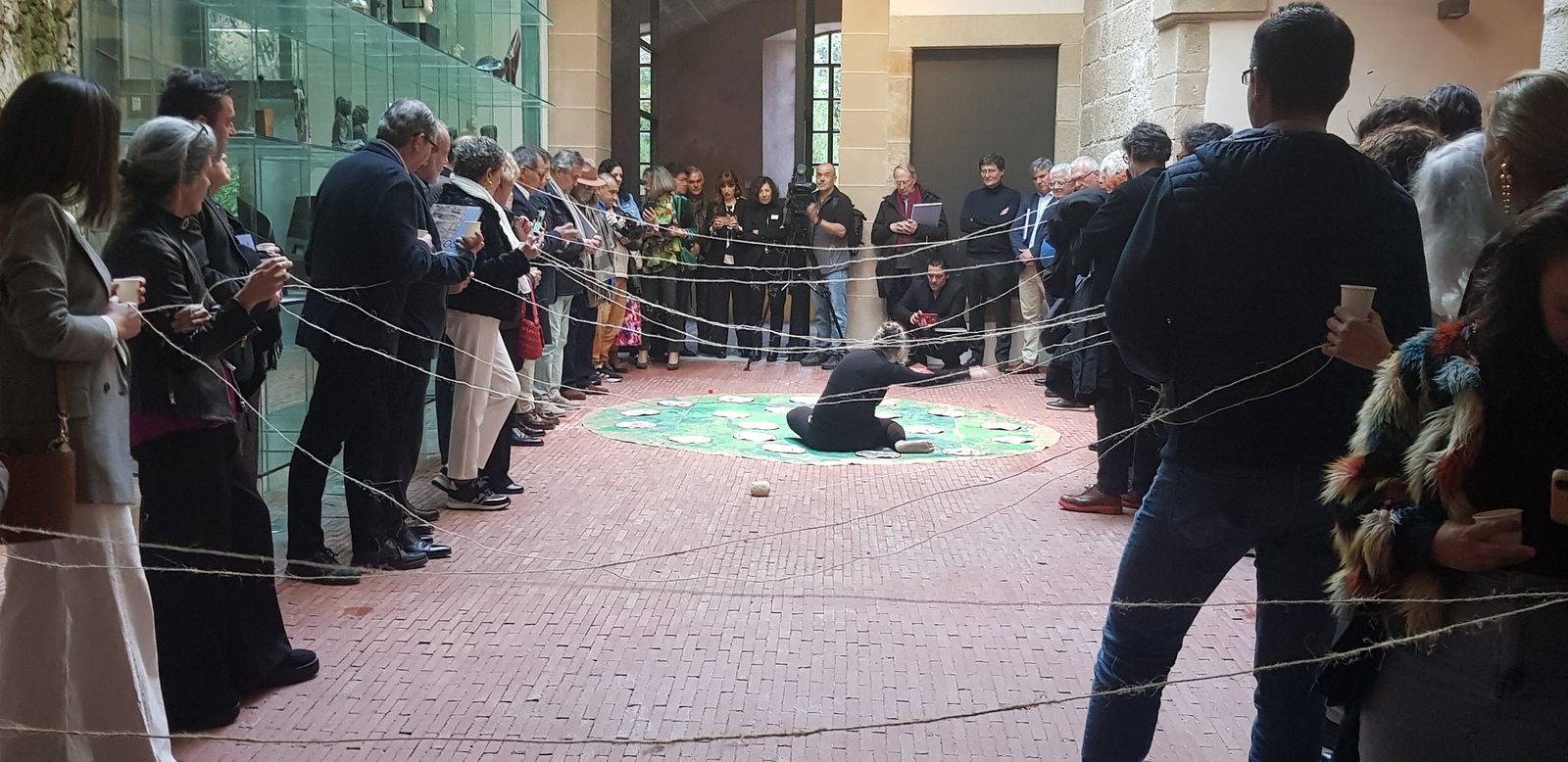 Coincidamos! / Let's Agree!, 2025, performance: the audience holds lines of twine around the painted cloth